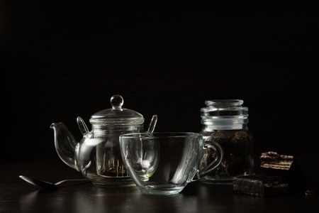 Cup for tea and teapot on a dark backgroundの写真素材