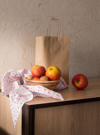 Still life with fresh ripe apples paper bag and a scarfの写真素材