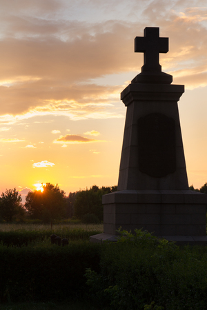 Monument with a cross on the sunset background.の写真素材