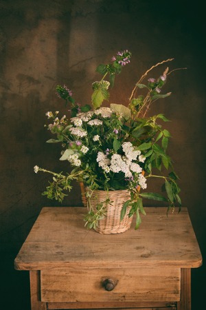 Vintage still life with wild flowers in a basketの写真素材