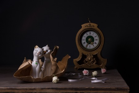 Still life with porcelain figurines and vintage clockの写真素材
