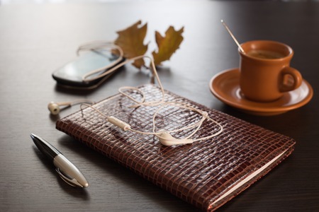 Autumn concept with diary, mobile phone and coffeeの写真素材