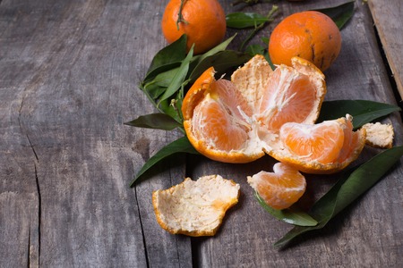 Ripe fresh tangerines on a old wooden tableの写真素材