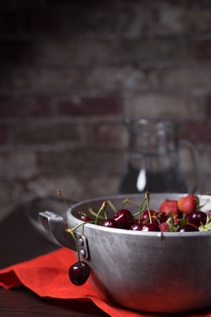 Fresh ripe juicy cherry and strawberries on the tableの写真素材