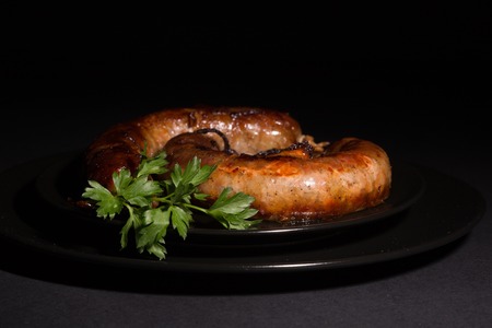 Delicious fresh homemade sausage on a black plateの写真素材