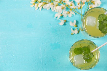 Refreshing drinks with mint on a turquoise background