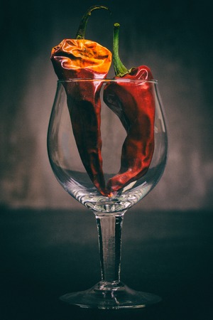 Two sharp red dry peppers in a glass