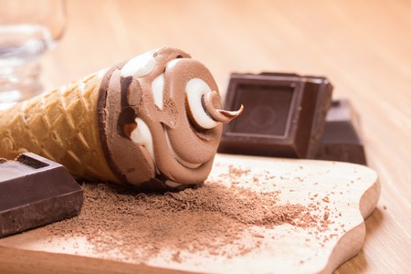 ice cream and pieces of dark chocolate on the tableの写真素材