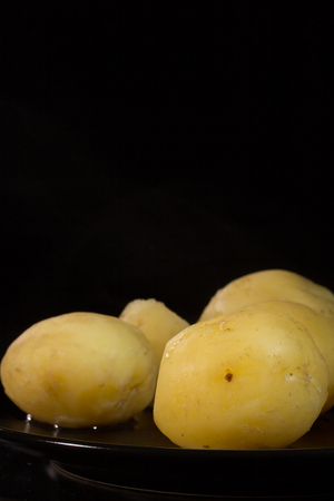Welded potatoes on a black plate on a dark backgroundの写真素材