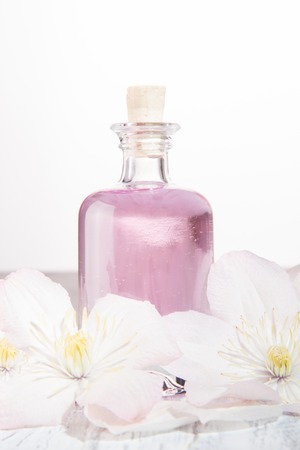 Perfume bottle and fresh white flowers over whiteの写真素材