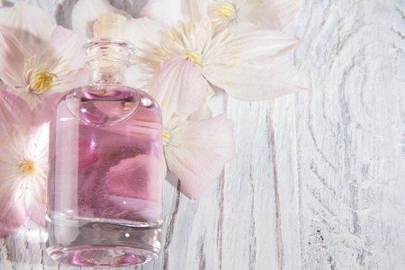 Perfume bottle and fresh white flowers over whiteの写真素材