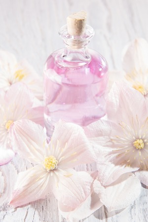 Perfume bottle and fresh white flowers over whiteの写真素材