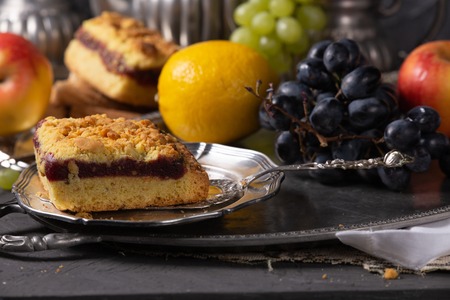 Still life with vintage silver items, fruits and sweetsの写真素材