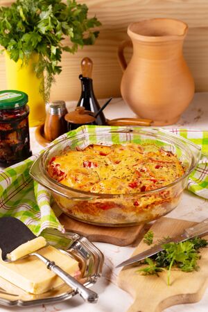Potaties baked with tomatoes and sweet peppers on the tableの写真素材