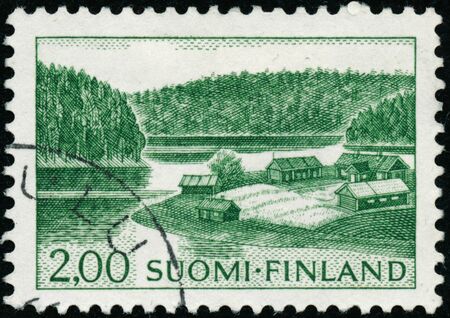 POLTAVA, UKRAINE - January 9, 2020. Vintage stamp printed in Finland circa 1963 show farm on lake shoreのeditorial素材