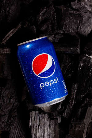 Metal can with pepsi cola on black charcoal background