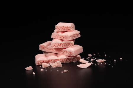Chunks of aerated pink chocolate on black backgroundの写真素材