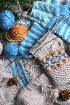 Flat lay of knitting and winter accessories on white wooden background