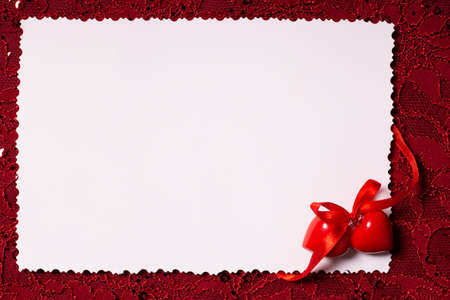 Red background with a lace pattern and a postcard for textの写真素材