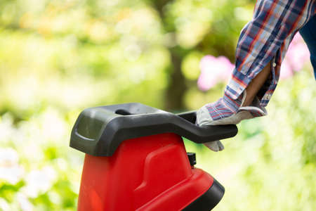Garden chipper, electric shredder mulcher against the background of the garden