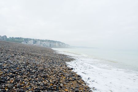 Pebble beach and shoreline at the Alabaster Coast in Dieppe, France. Quiet melancholic day in October.の写真素材