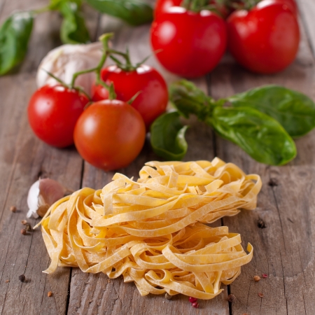 raw pasta with tomato and basil, square imageの写真素材