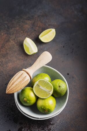 Fresh green limes in the ceramic bowl, selective focus image