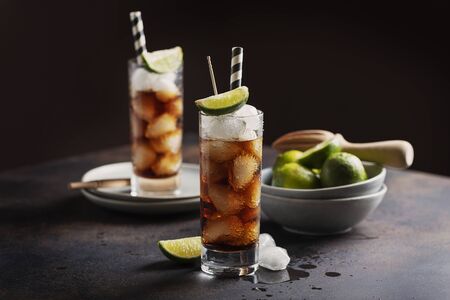 Alcoholic cocktail cuba libre with cola, rum, ice and lime, selective focus