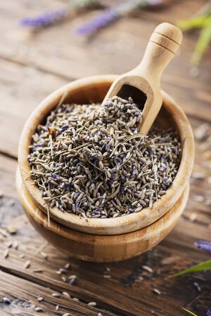 Dried lavender flowers in a wooden bowl on the rustic background, selective focusの写真素材
