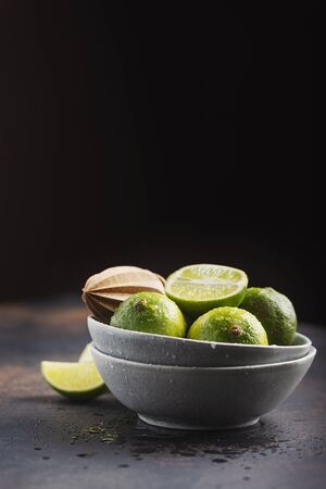 Fresh green limes in the ceramic bowl, selective focus imageの写真素材