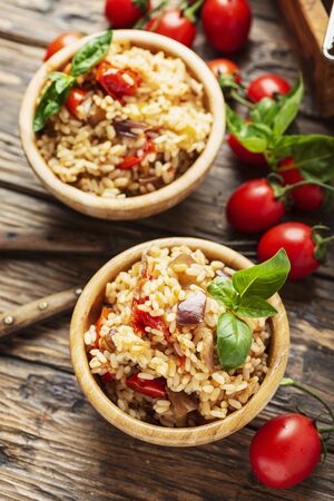 Vegetarian rice with onion, tomato and eggplant, rustic style and selective focus imageの写真素材