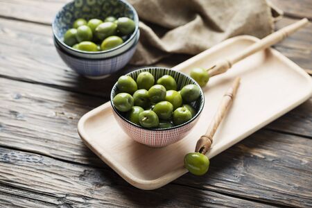 Green Italian olives on the wooden table, selective focusの写真素材