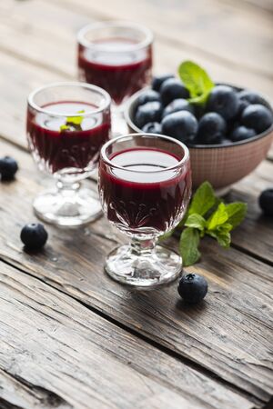 Sweet blueberry liqueur on the wooden table, selective focus imageの写真素材