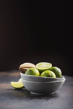 Fresh green limes in the ceramic bowl, selective focus imageの写真素材