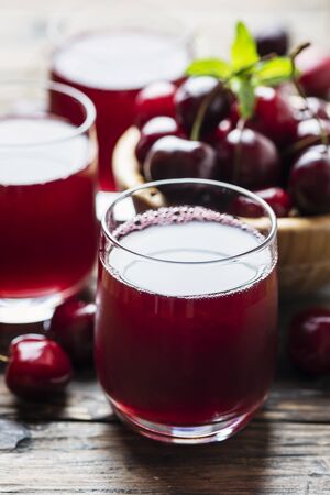 Fresh cherry juice on the wooden table, rustic style and selective focus imageの写真素材