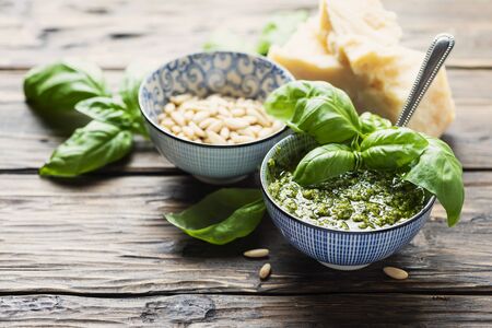 Typical Italian pesto with basil,  cheese, pine nut and oil, rustic style and selective focus imageの写真素材