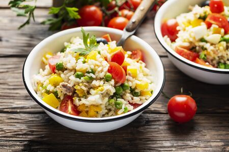 Cold summer salad with rice, tuna, green pea and tomato, rustic style and selective focusの写真素材