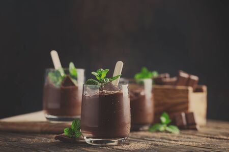 Sweet mousse with chocolate and mint on the rustic table, selective focus and toned imageの写真素材