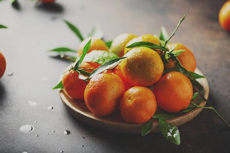 Sweet fresh mandarins on the black table, selective focus and toned imageの写真素材