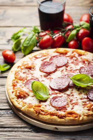 Italian pizza with tomato and salami, rustic stlye and selective focus imageの写真素材