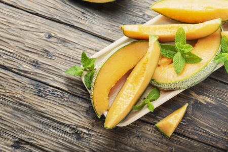 Sweet yellow fresh melon on the wooden table, selective focus imageの写真素材