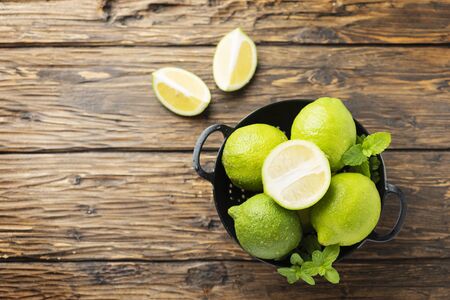 Fresh green limes on the wooden table, selective focus imageの写真素材