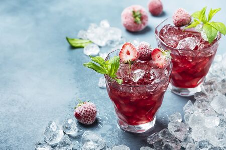 Red summer cocktail with frozen strawberry, ice and mint, selective focus imageの写真素材