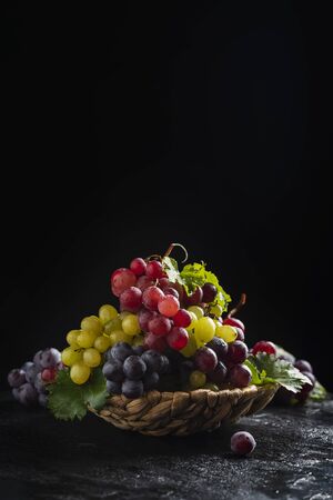 Mix of red and yellow grape on the black background, selective focusの写真素材