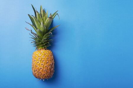 Fresh pineapple on the blue background. Summer concept and top vie image with a copy spaceの写真素材