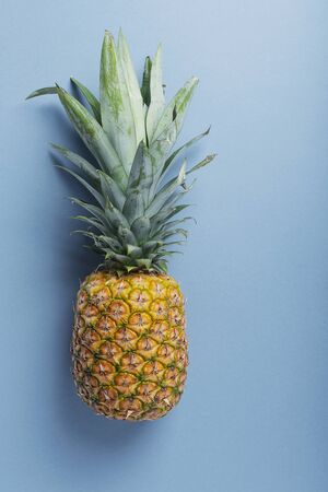 Fresh sweet pineapple on the blue background. Summer concept, top view with a copy space for your textの写真素材