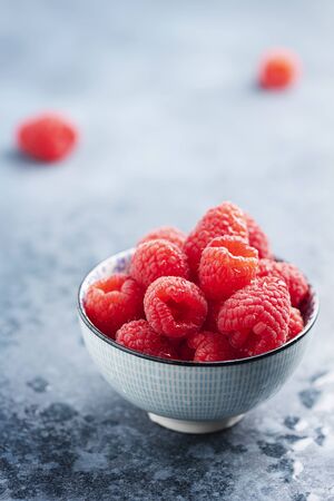 Fresh sweet raspberry in the ceramic bowl, selective focus image