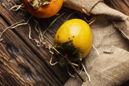 Fresh sweet persimmon on the wooden table, selective focusの写真素材