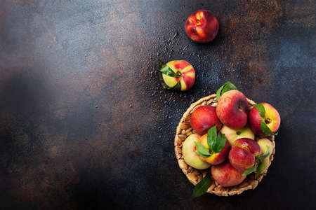 Concept of healthy vegan food. Top down view of sweet peaches with green leaves. Image with copy space for your textの写真素材