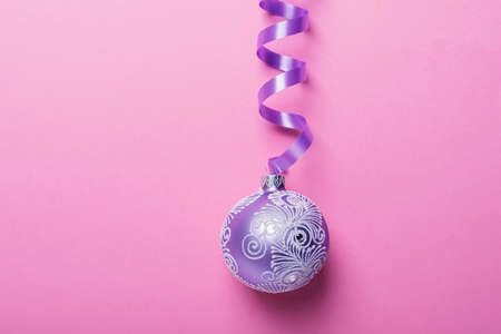 Christmas violet ball on the pink background, christmas concept. Top down view with copy space for textの写真素材